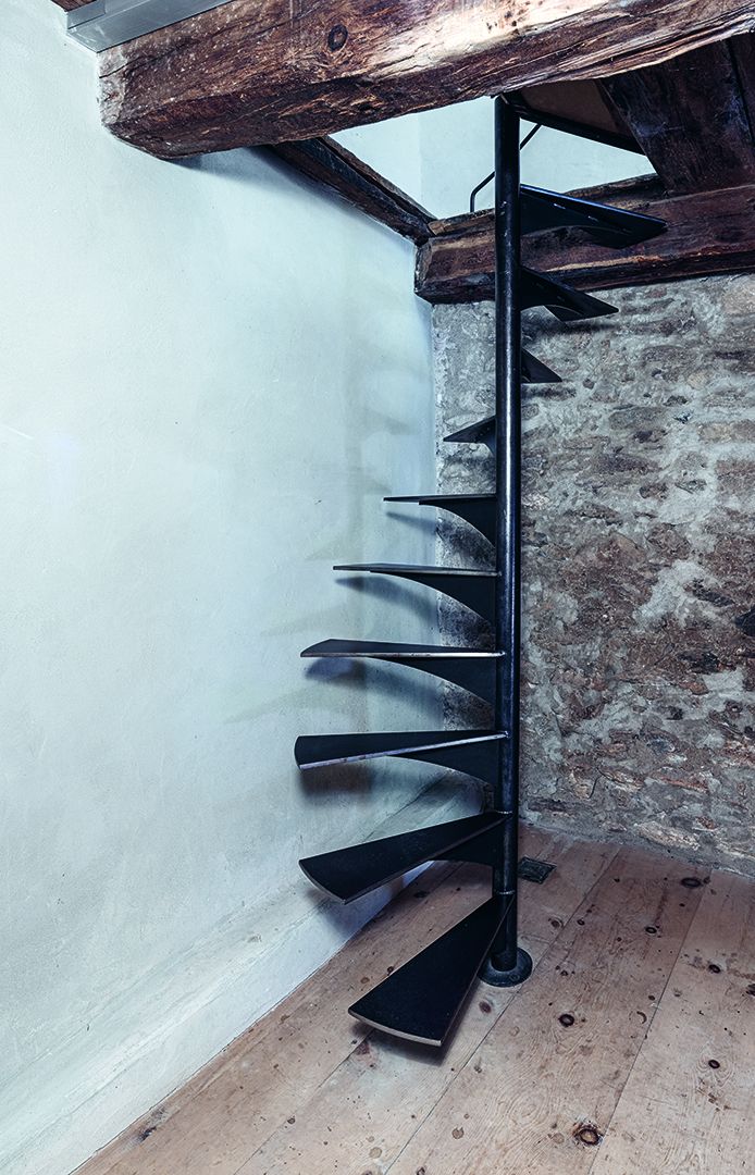 Treppe aus rohem Stahl geölt, mit geschwungener Innenwange in einem historischen Wohnhaus.